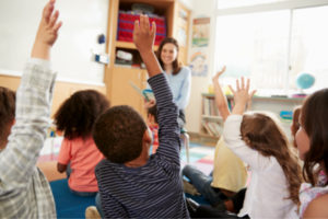 children with hands raised 